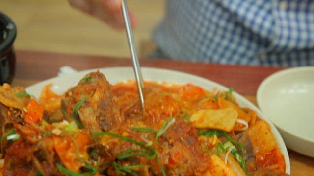 매콤한 뼈찜에서 당면을 들어올리는 젓가락