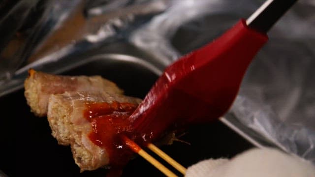 주방에서 꼬치구이에 소스를 바르는 모습