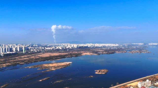 Riverside Cityscape with Sandbank and Skyline