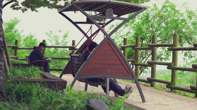 공원에서 그네를 타며 휴식하는 커플