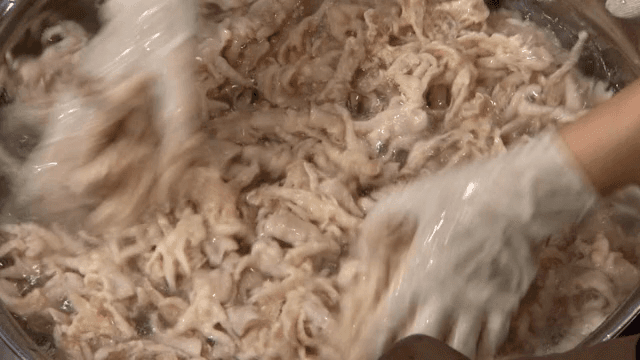 얼음물 안에 있는 생닭발을 손으로 섞기