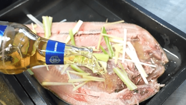 Fish being prepared with seasoning and sauce