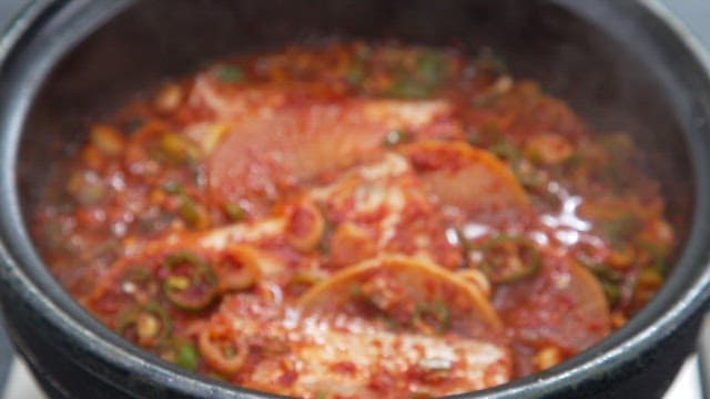 냄비에서 끓고 있는 무와 매운 양념이 들어간 갈치 조림