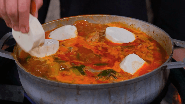 냄비에서 끓고 있는 찌개에 카사바 넣기