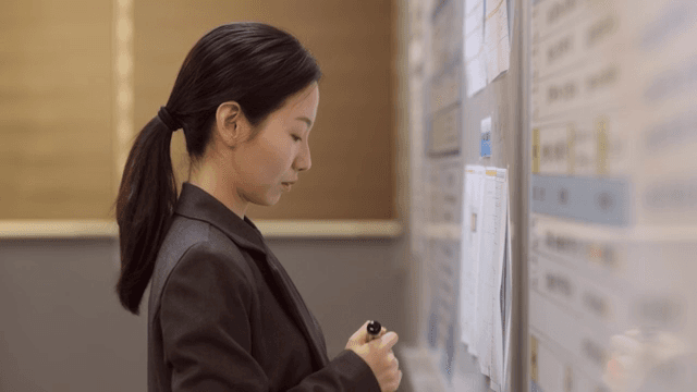 Woman writing on a board in an office
