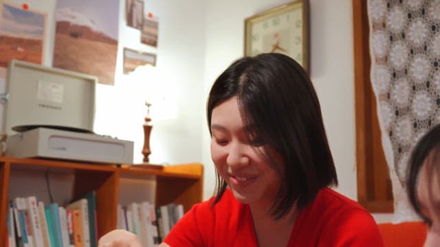 실내에서 카드 놀이하는 빨간 스웨터 여성