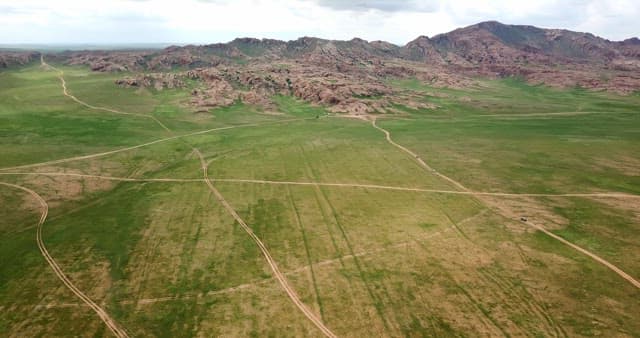 Vast green plains with mountains