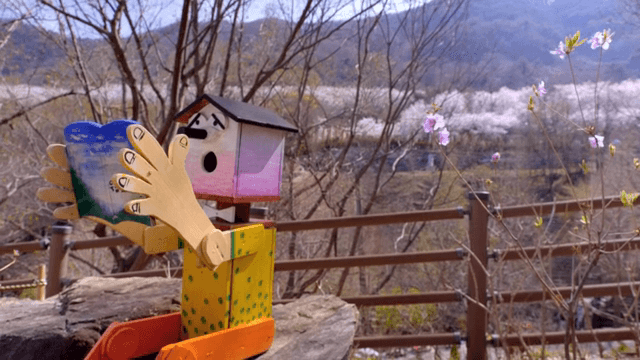 나무 조각상과 꽃이 핀 공원