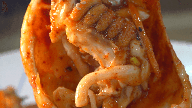 Spicy Squid Seafood Stew Lifted with Tongs