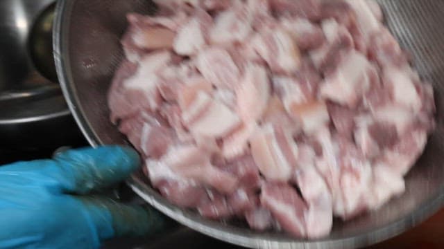 식당 주방에서 신선한 돼지고기를 김치찌개에 넣기