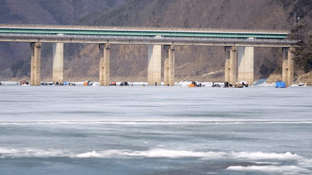 다리 아래에서 얼음 낚시하는 사람들