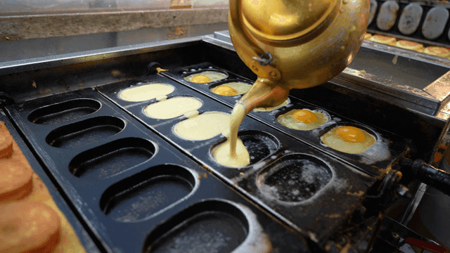 Kettle pouring egg batter into mold