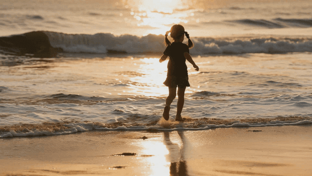 Silhouette of a girl running onto the beach at sunset