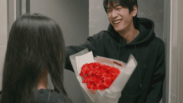 현관에서 꽃을 주고받는 커플