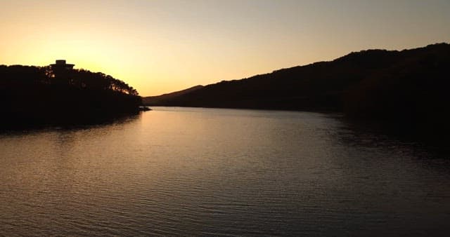 Sunset over a calm river with a bridge