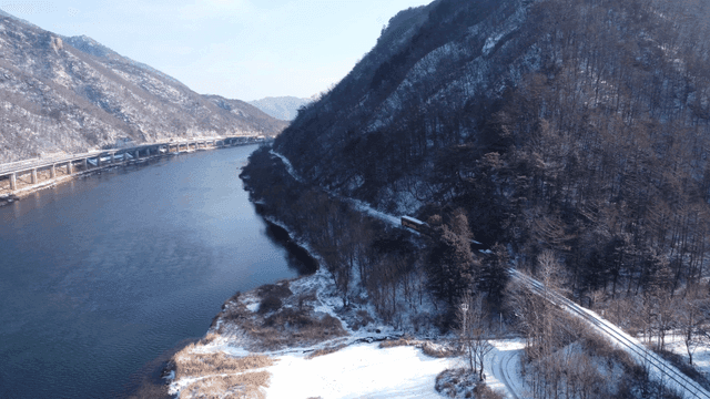 기차가 지나가는 눈 덮인 강 풍경