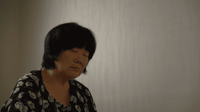 An elderly woman sitting indoors