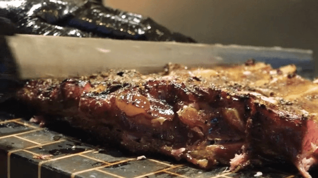 Juicy Galbi being sliced on a cutting board