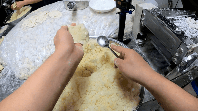 만두피에 다진 당면을 빠르게 퍼넣는 요리사