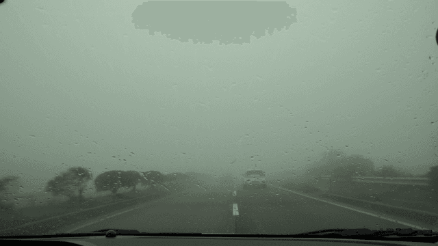 Rainy road with fog and cars