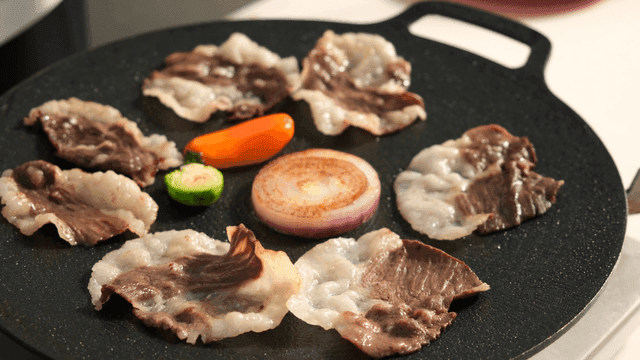 Grilling meat and vegetables on a pan