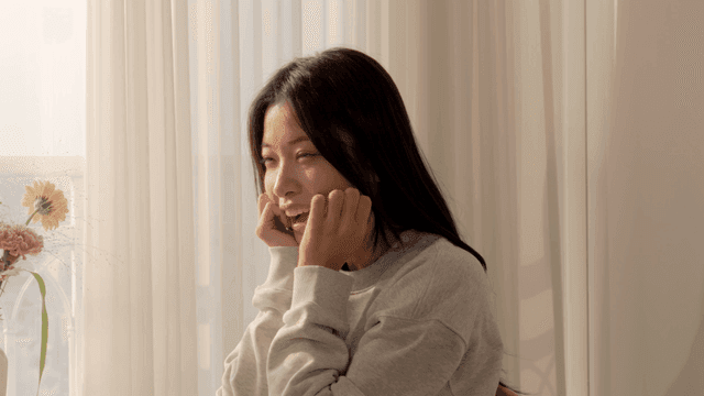 햇살 가득한 창가에서 미소 짓는 여성