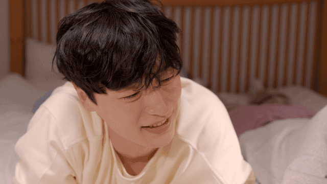 Young man smiling and talking on bed