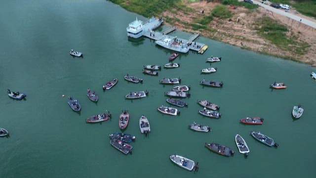 Boats gathering near a dock on a calm river