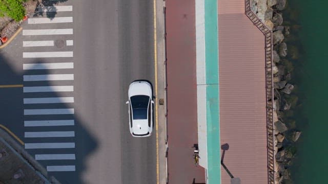 평온한 강변 산책로와 차가 다니는 도로