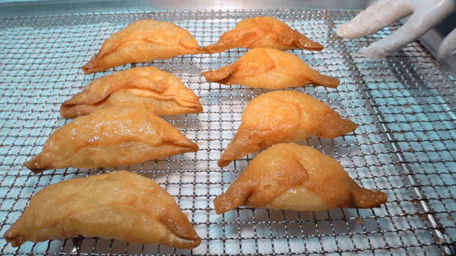 식힘망 위에 잘 줄지어진 튀긴 만두들