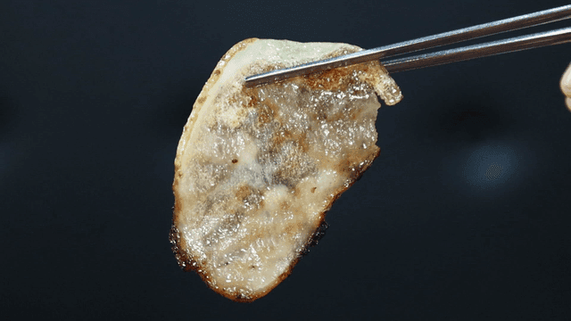 Grilled thinly sliced ​​pork belly picked up with chopsticks