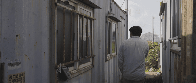 Man opening a door of a container building