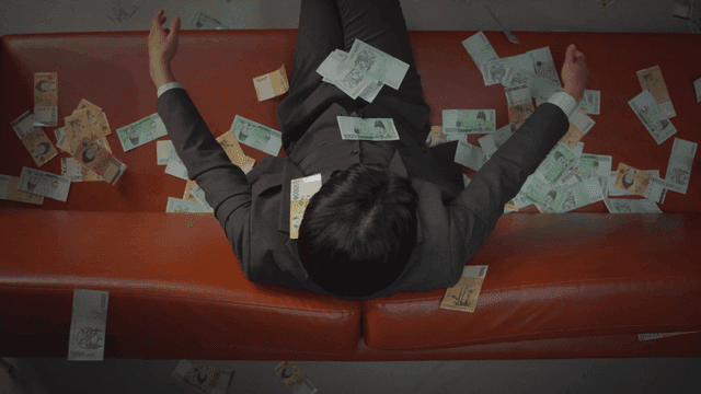 Man sitting on a sofa throwing money