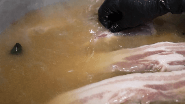 Pork belly boiling in a pot