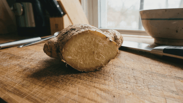 나무 도마 위의 신선한 생강 뿌리