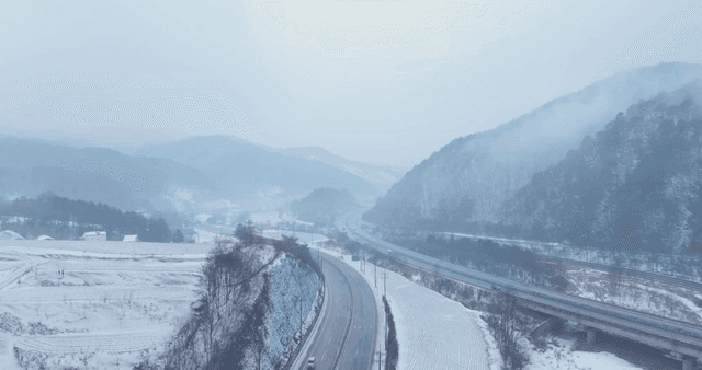 Winding snow-covered road along mountain valley