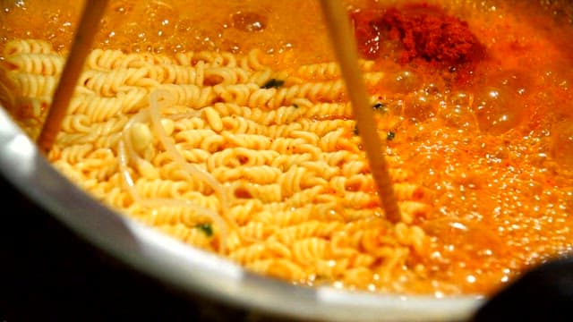 Ramen noodles boiling in a spicy broth