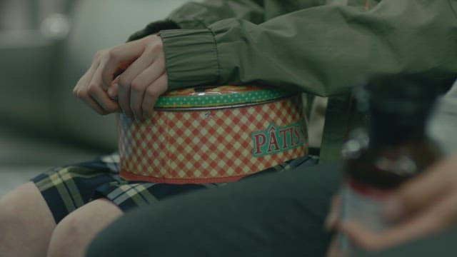 동그란 틴케이스와 화학약품병을 들고 있는 손