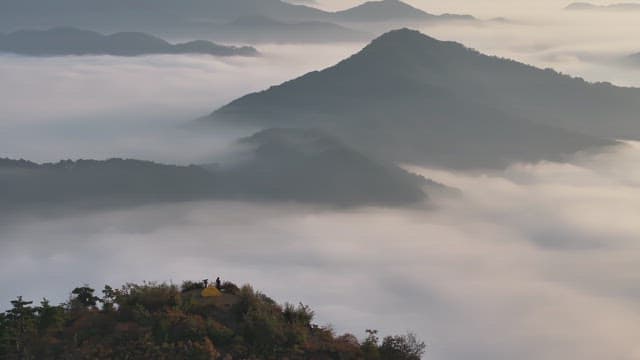 구름 낀 산 꼭대기에서 캠핑하는 모습