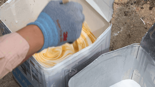 Construction workers mixing paint