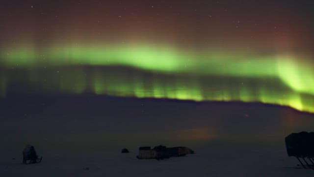 Aurora Borealis over a snowy landscape at night