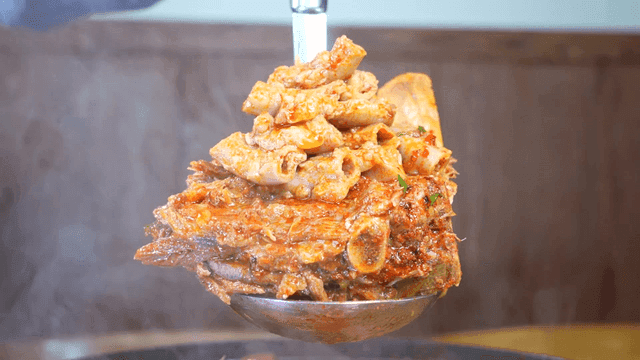 Ladle ladle full of steaming hot, spicy tripe and pork backbone stew 