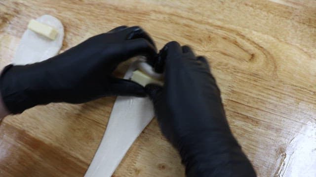 반죽 안에 소금빵을 넣고 마는 장면