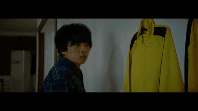 실내에서 노란색 재킷을 바라보는 사람