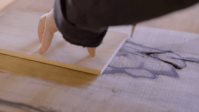 나무 판자를 측정하고 표시하는 손