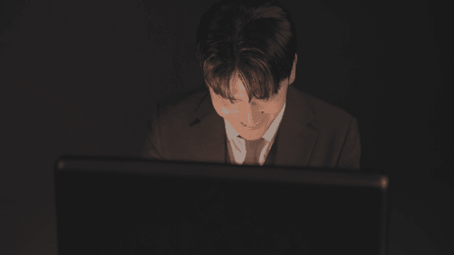 서류 가방을 열자 미소 짓는 정장을 입은 남자