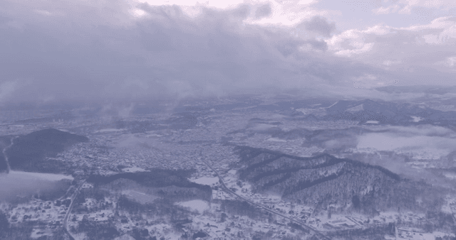 Snow-covered town with misty mountains
