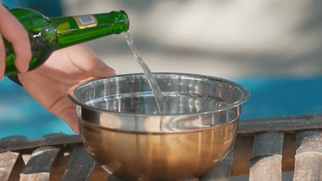 야외에서 금속 그릇에 맥주를 붓는 장면