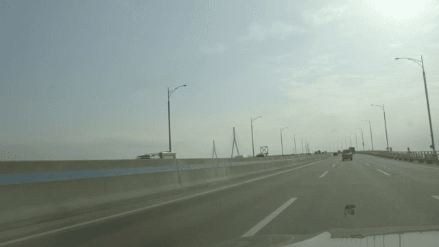 맑은 하늘 아래 다리 위를 달리는 차들