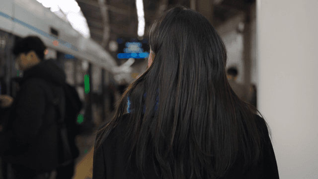 Back view of a woman moving on a subway platform